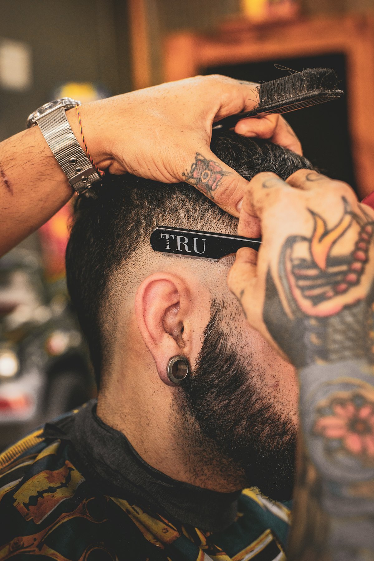Barber carefully shaping a client's haircut