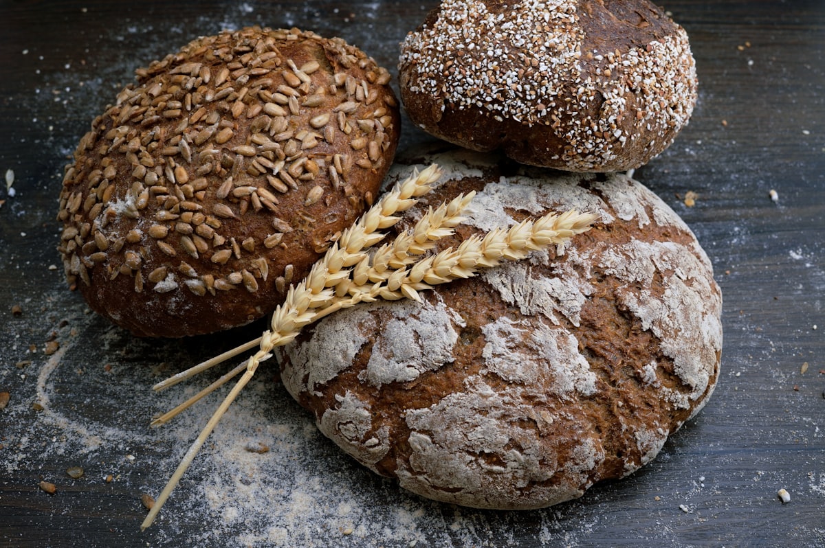 Fresh artisan sourdough loaves cooling on a wooden bakery counter
